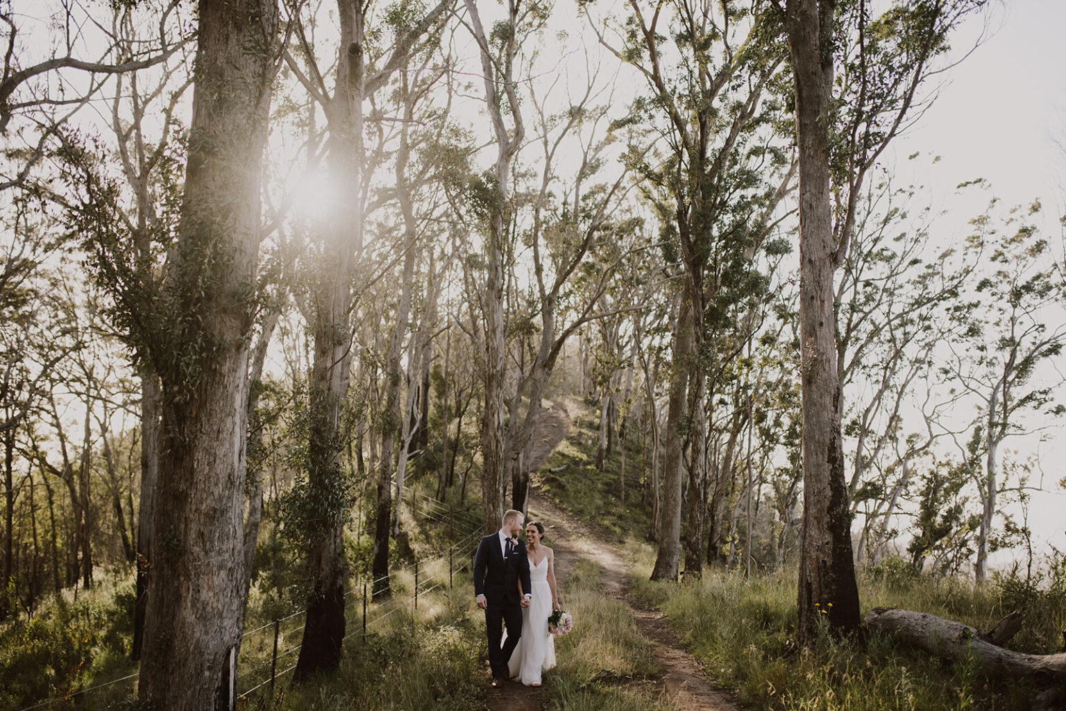 Couple walking along a forest track among tall gums