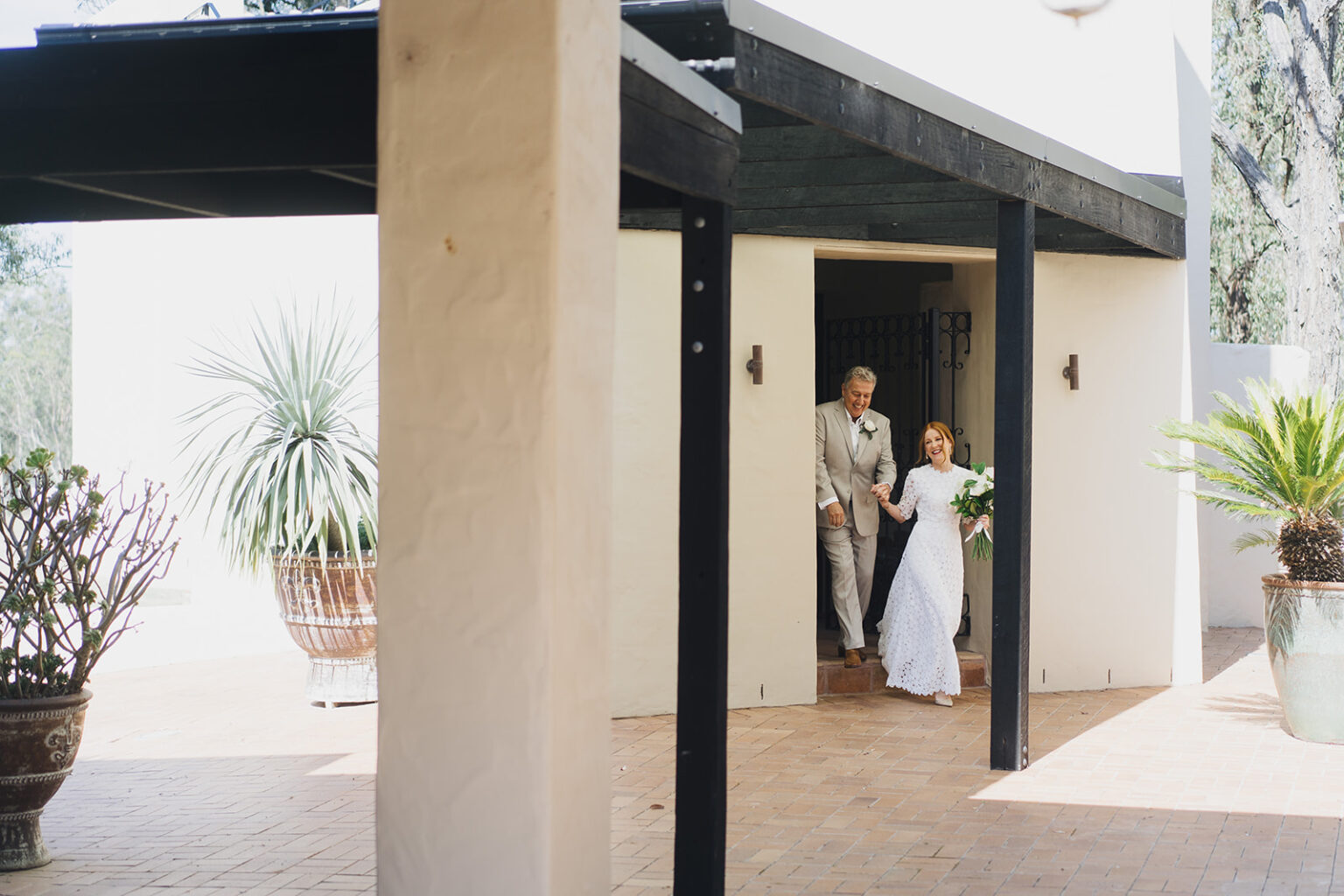 Couple stepping out of a shaded colonnade at Tower Lodge