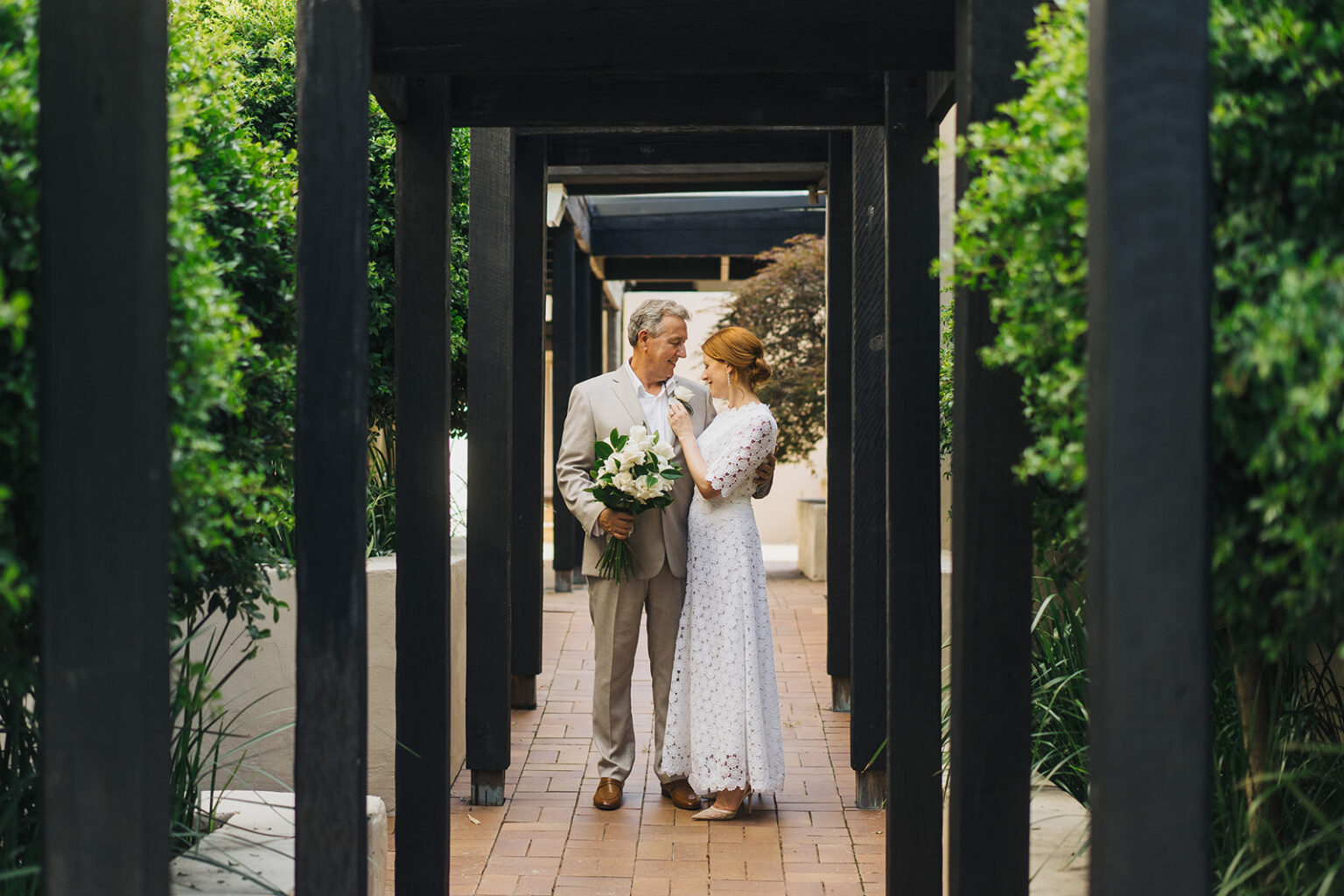 Couple walking through a timber pergola at Tower Lodge