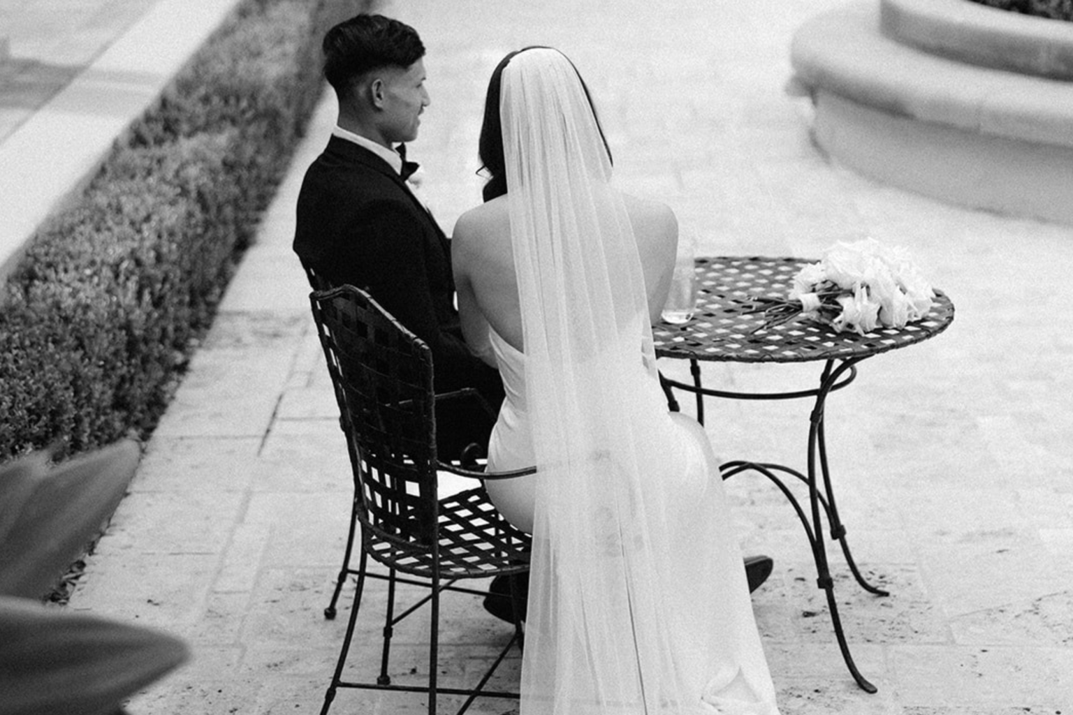Black-and-white photo of a couple at a courtyard table, Tower Lodge