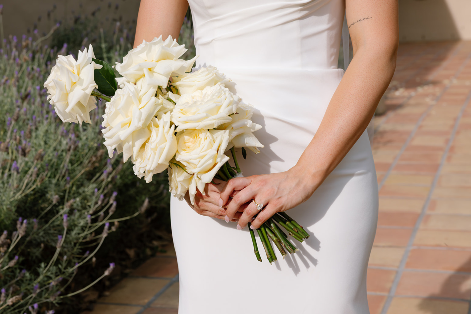 Bride holding a bouquet of white roses at Tower Lodge
