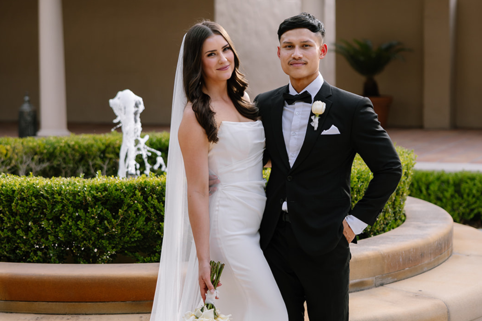 Bride and groom by the courtyard fountain at Tower Lodge