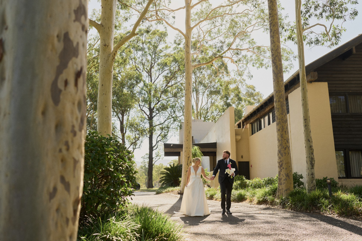 Couple walking through the gum trees at Tower Lodge, Pokolbin