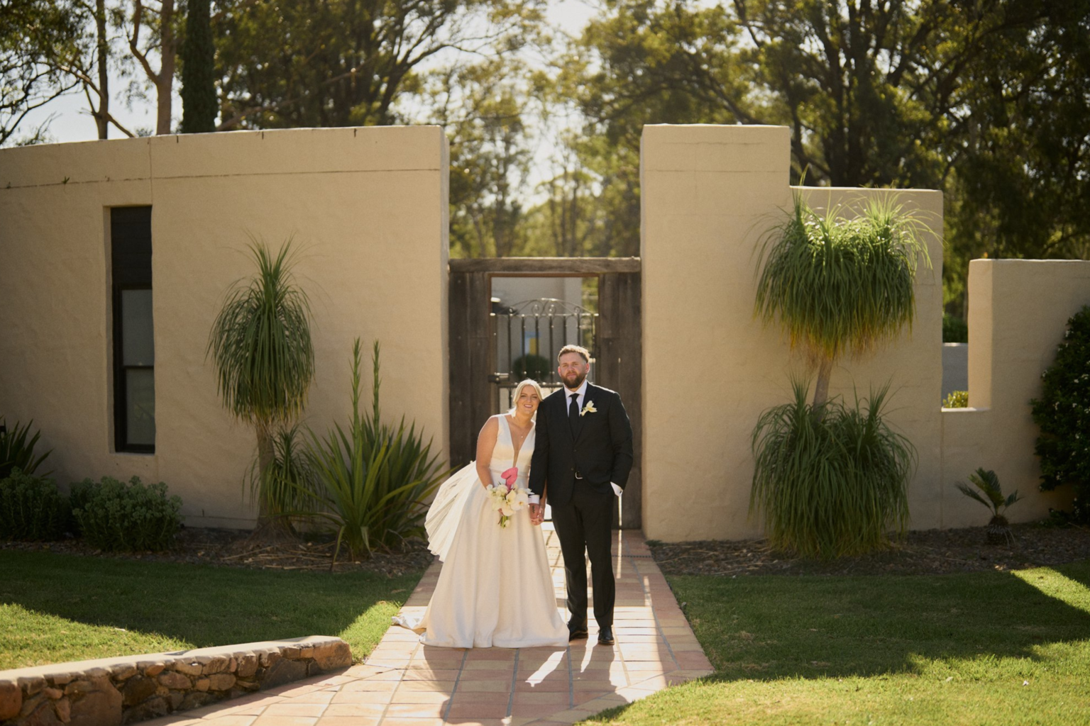 Couple walking through a garden gateway at Tower Lodge
