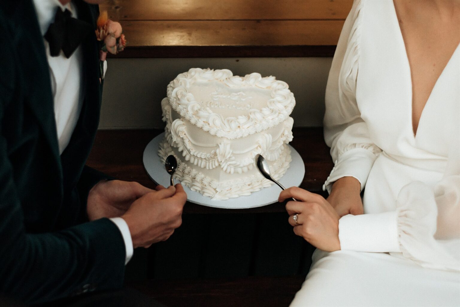 Couple cutting a heart-shaped wedding cake