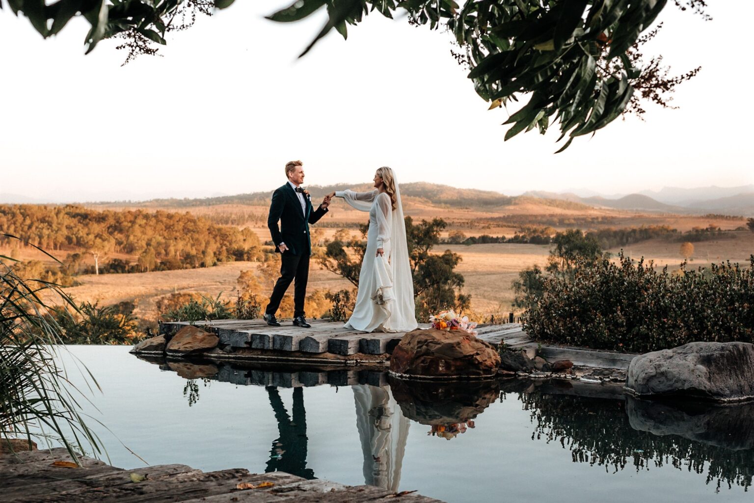 Couple reflected in the infinity pond overlooking the Scenic Rim