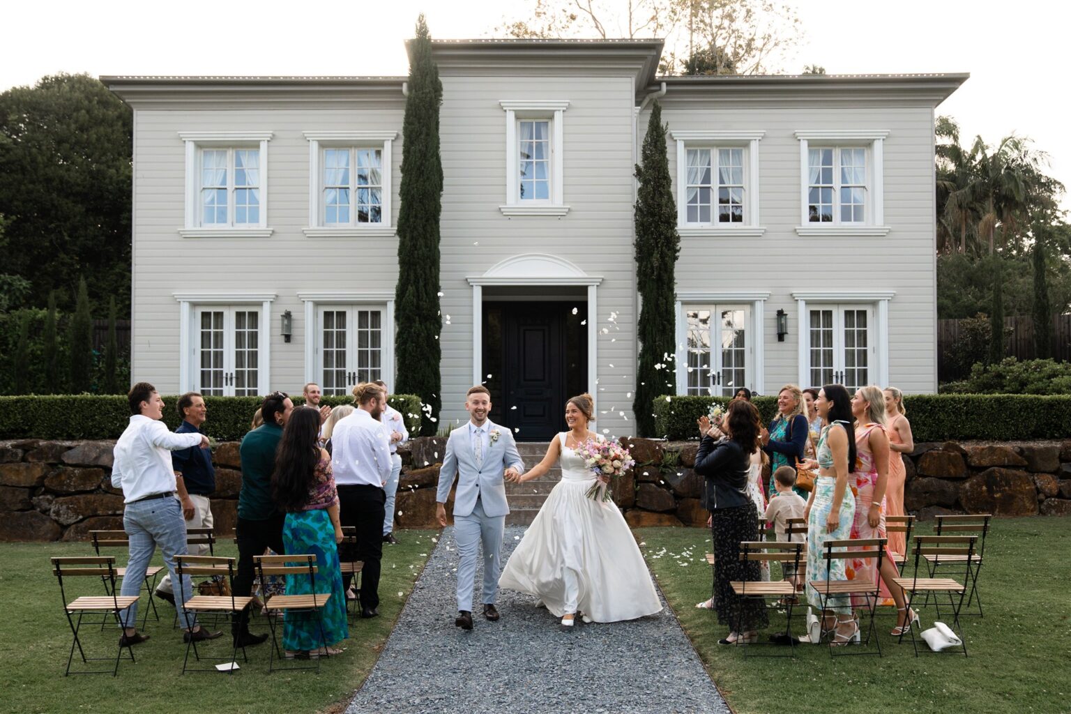Newlyweds walking up the aisle past guests at the House Steps