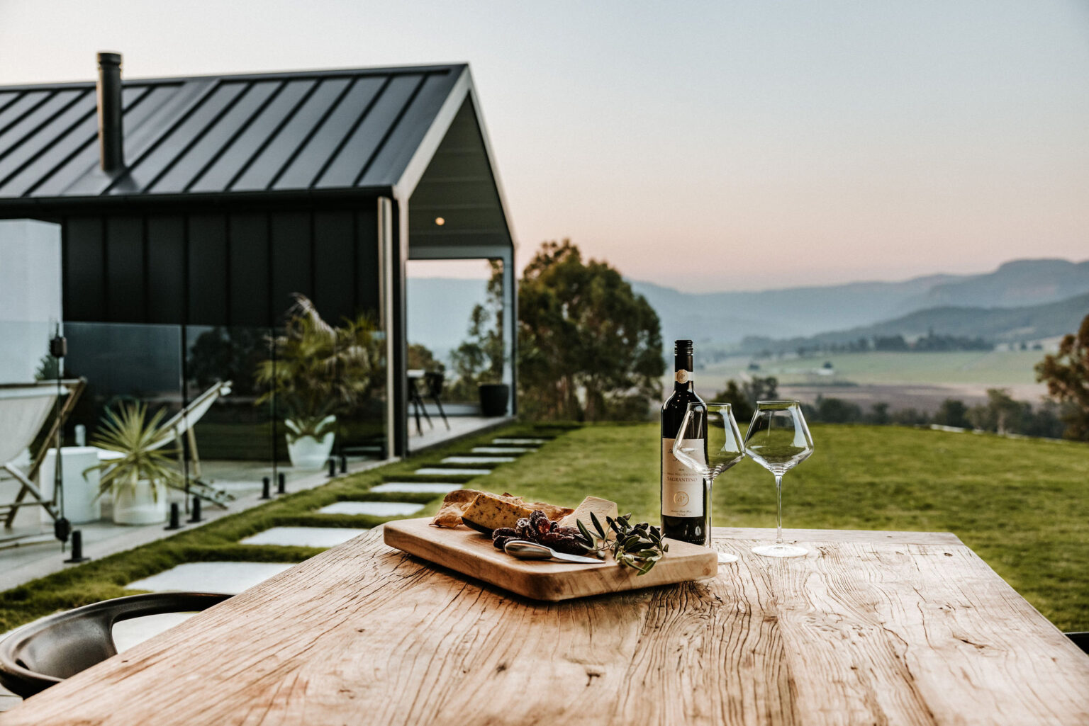 Grazing board and wine on an outdoor table with valley views