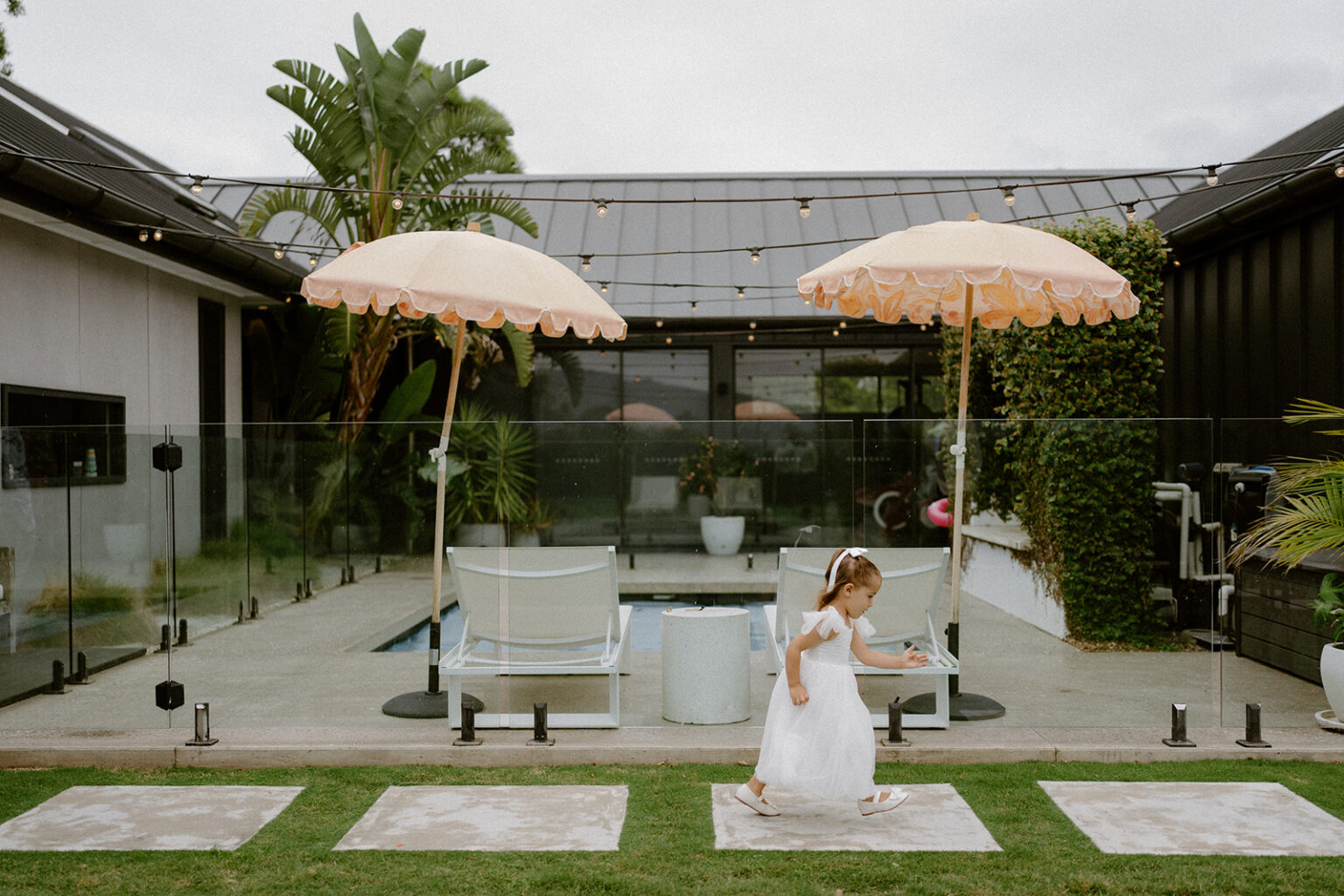 Bride twirling by the pool with fringed umbrellas at La Belle Vallée