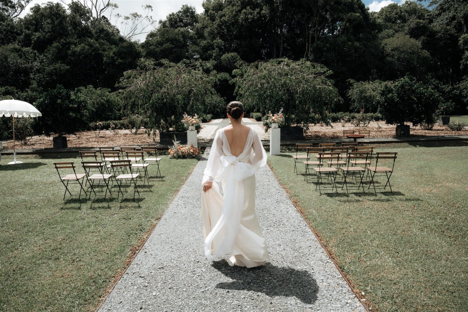Bride walking down the aisle between ceremony chairs at Wynmère Estate