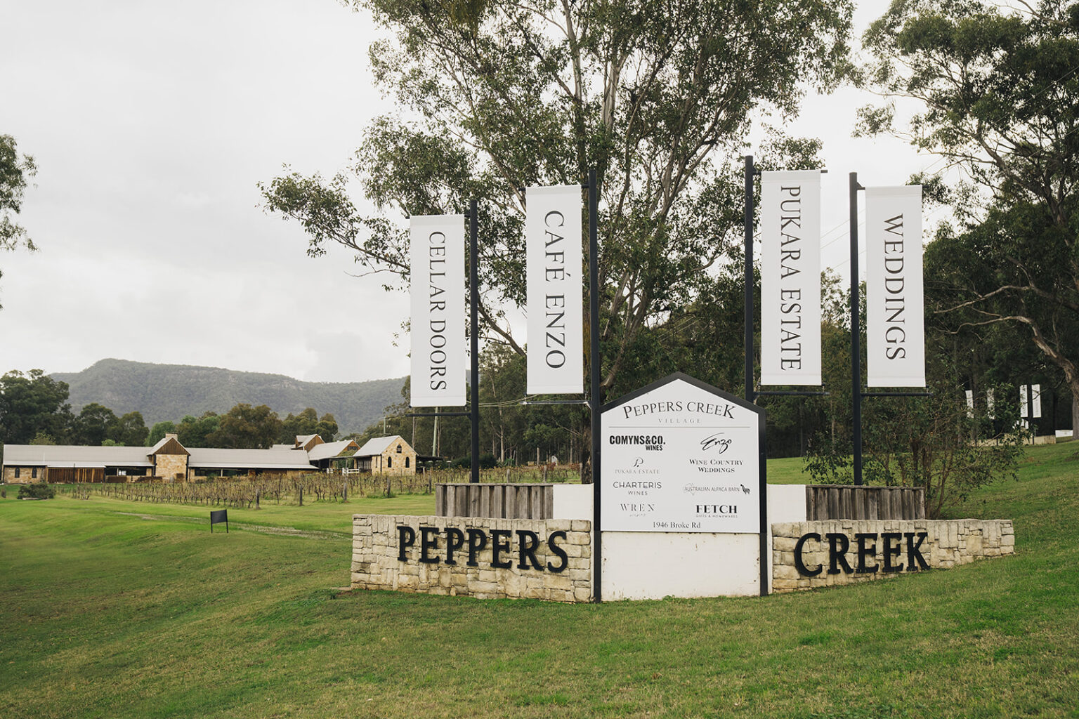 Peppers Creek entrance sign with Café Enzo and wedding banners