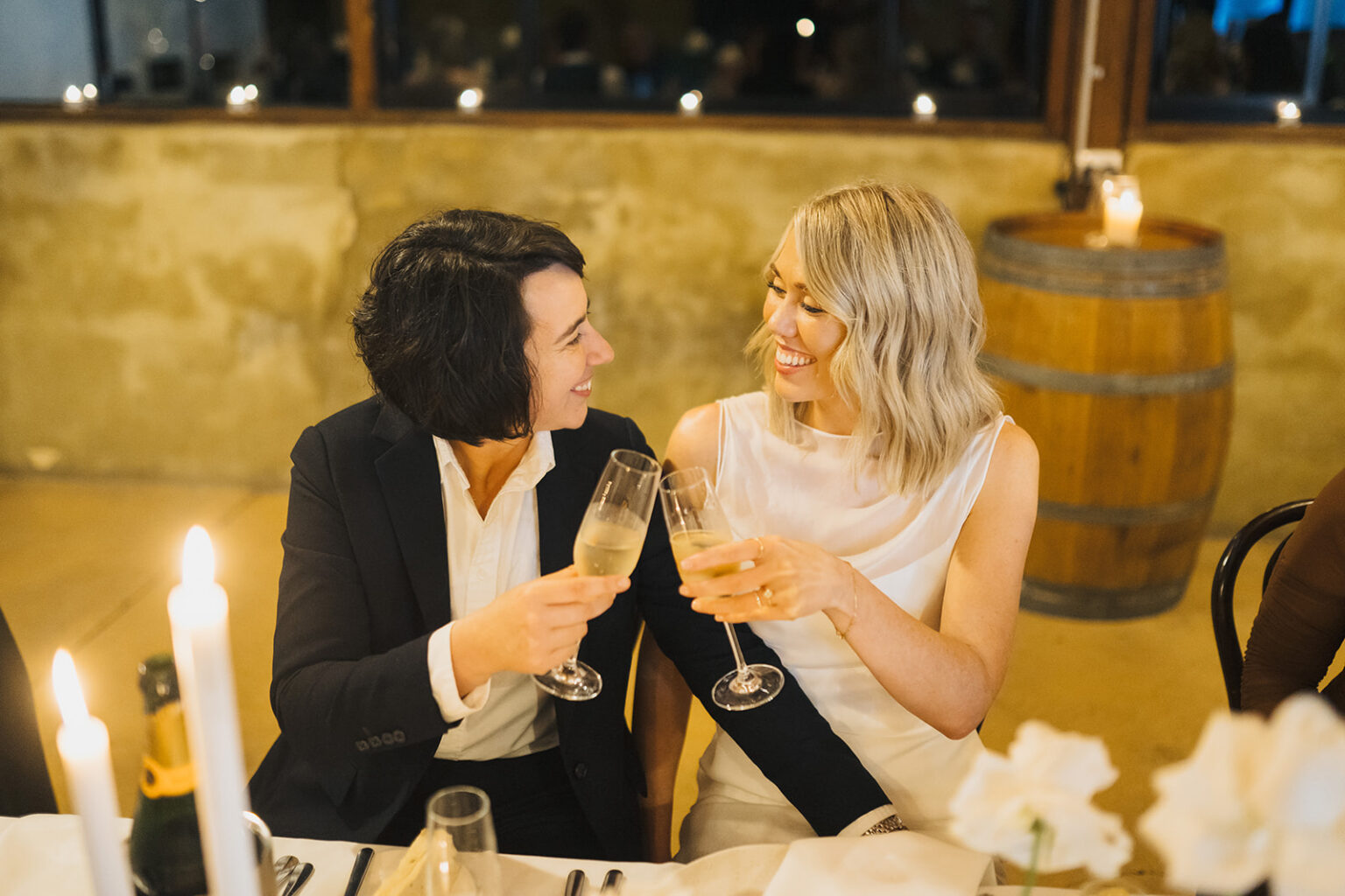Couple toasting with champagne at their candlelit reception