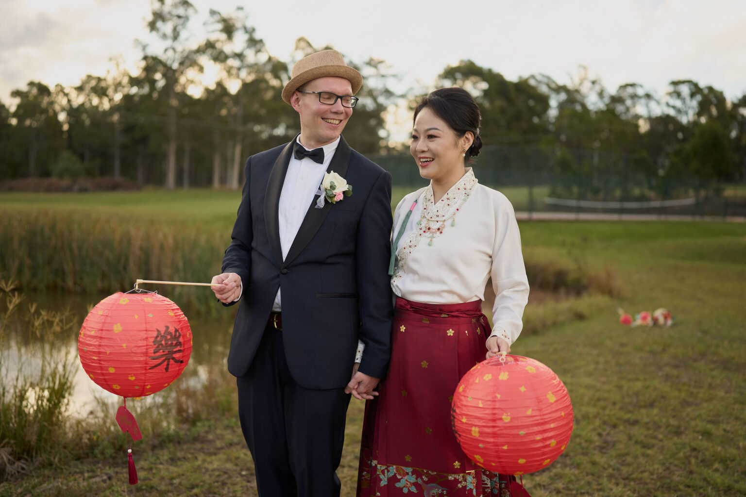 Couple holding red lanterns by the dam
