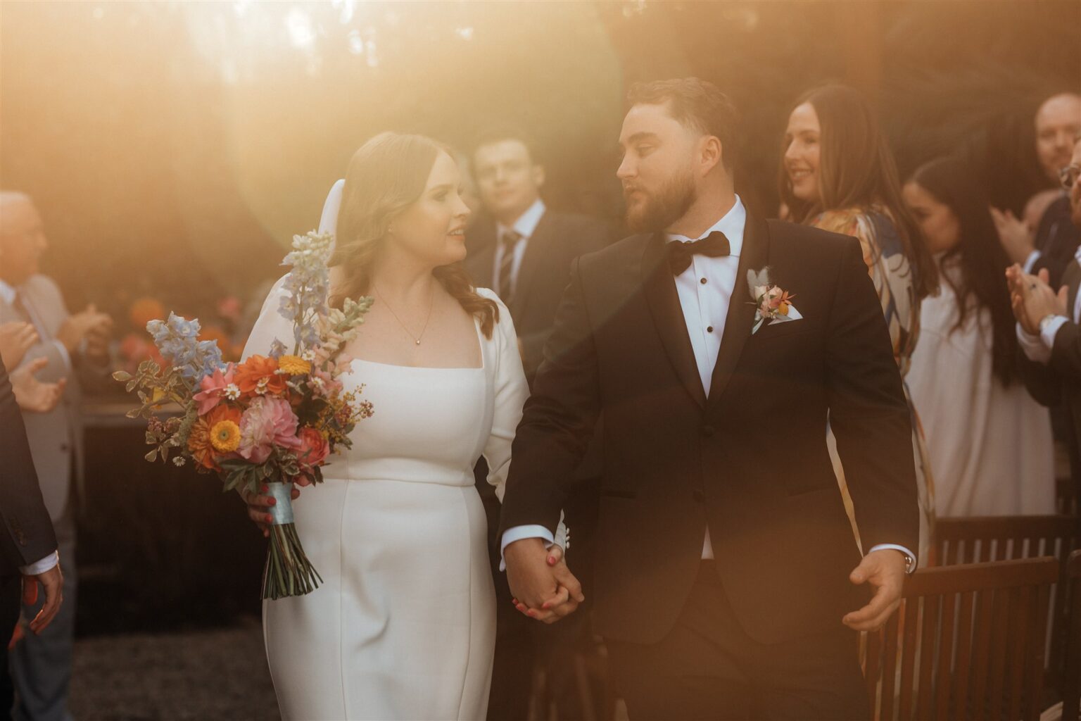 Newlyweds walking back down the aisle past smiling guests