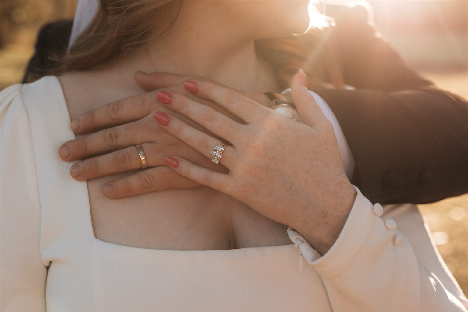 Close-up of the bride's hand and ring resting on the groom's