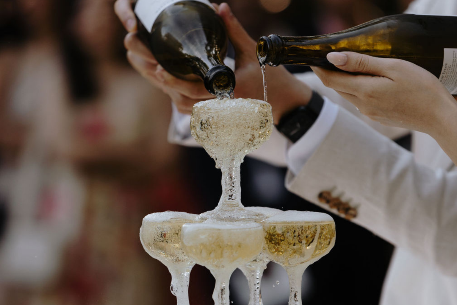 Close-up of champagne being poured into a coupe tower