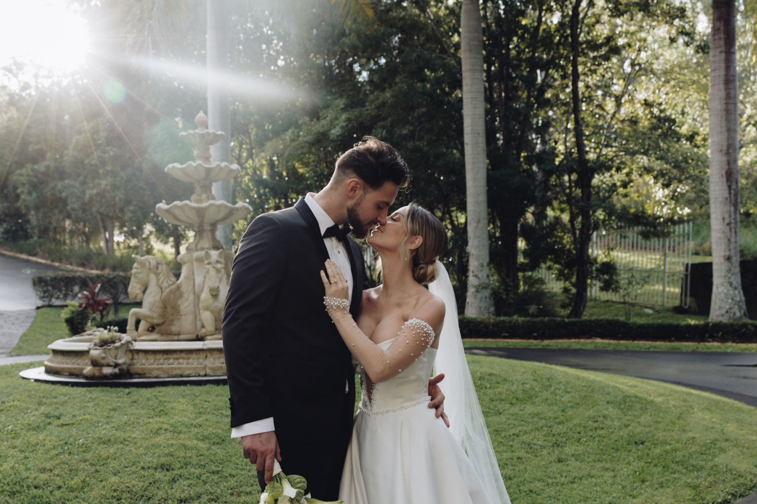 Couple kissing beside the fountain in soft sunlight