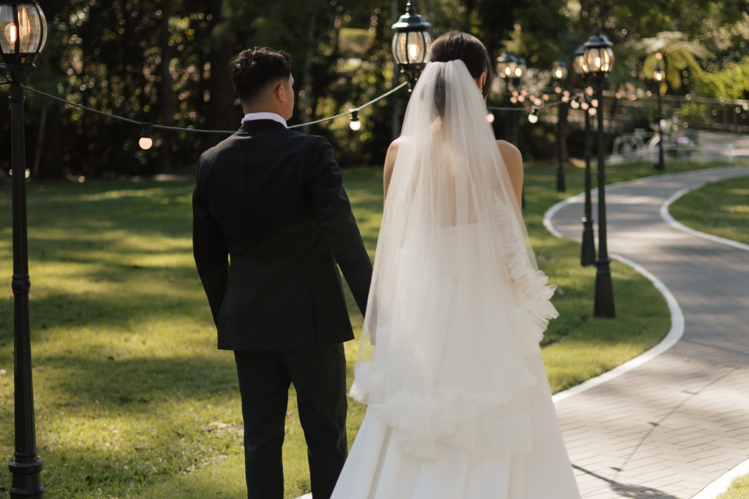 Couple walking along the lamp-lined garden path at Coolibah Downs
