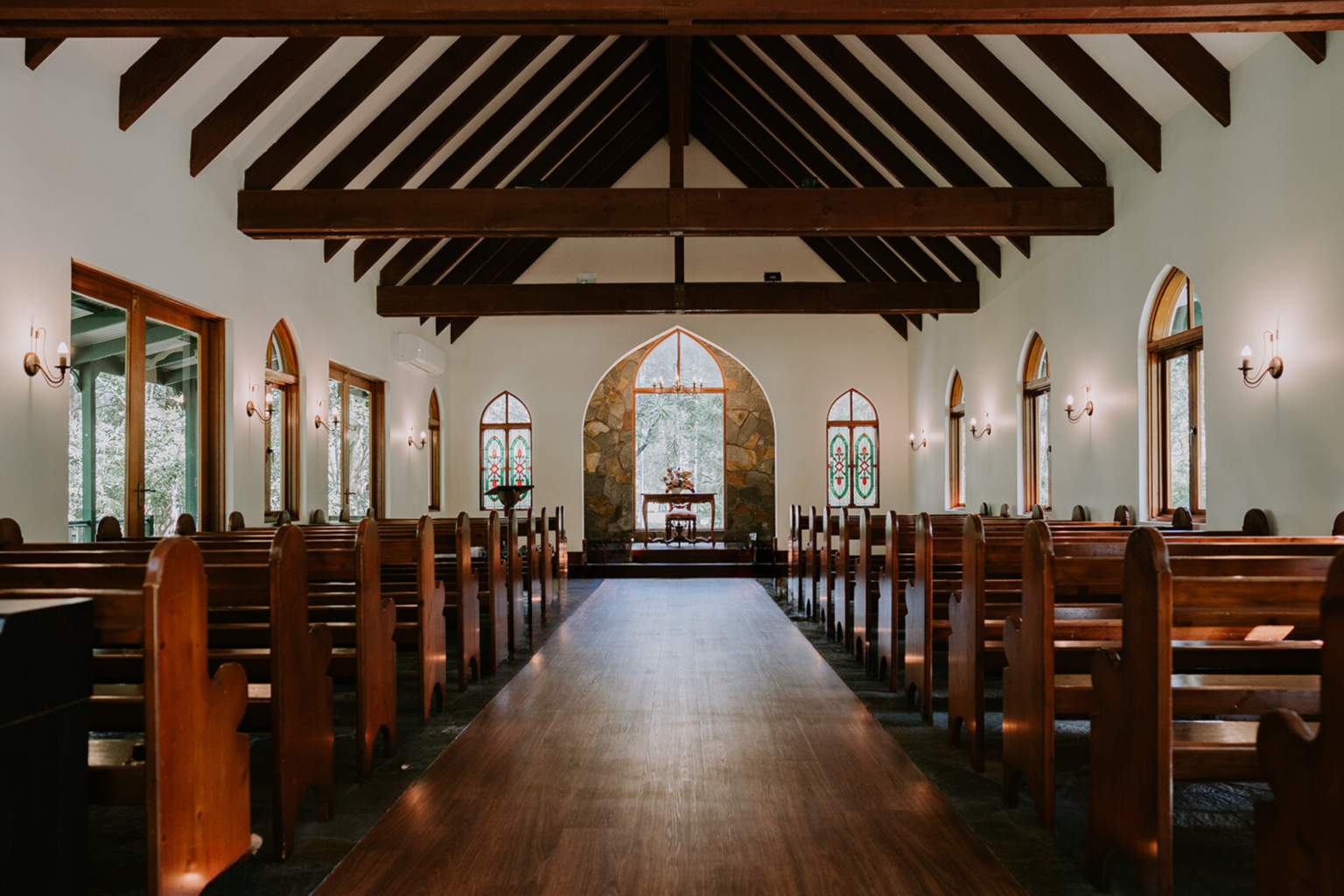 Timber pews and vaulted ceiling inside the chapel at Coolibah Downs