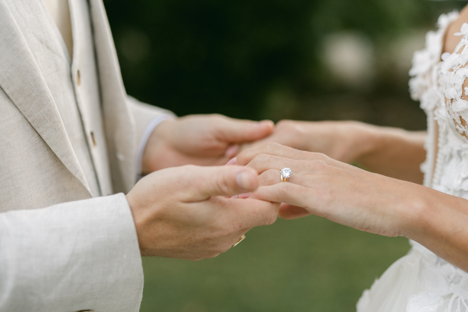 Close-up of the groom placing the ring on the bride's finger