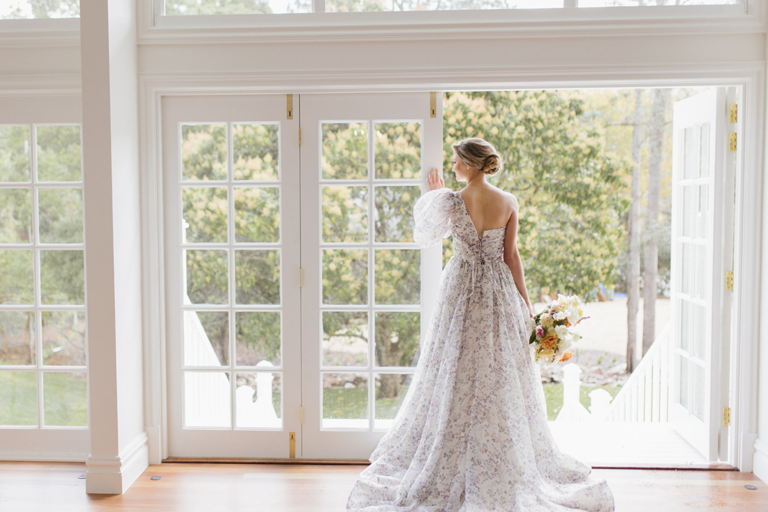 Bride in a lace gown by the French doors at Kwila Lodge