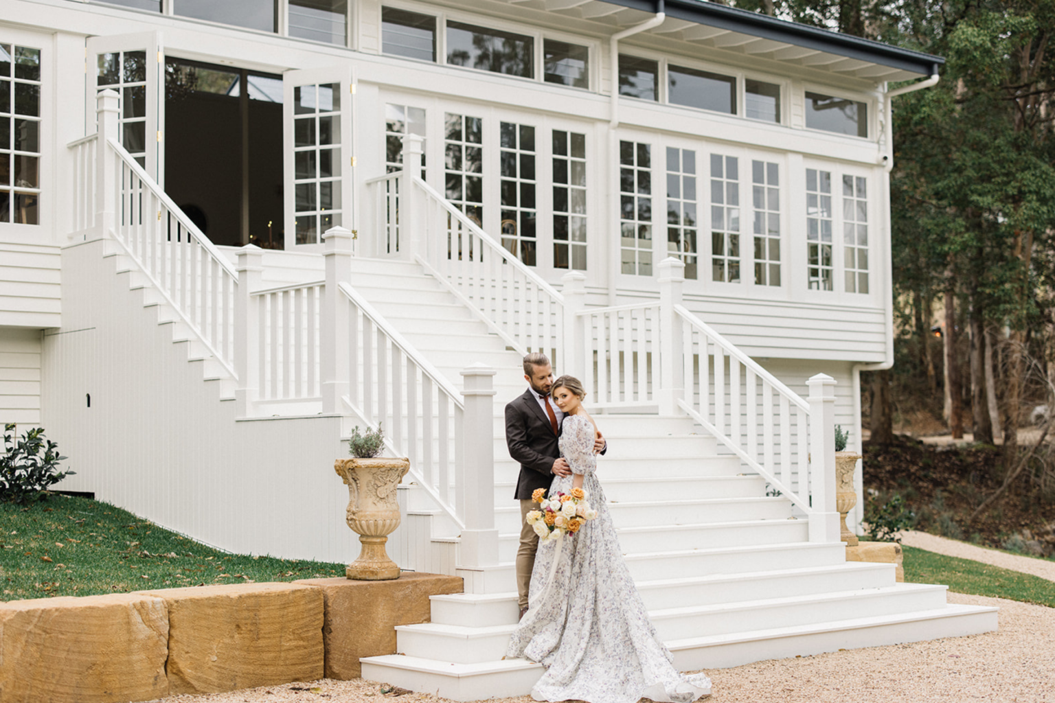 Couple at the foot of the white staircase at Kwila Lodge, Mudgeeraba