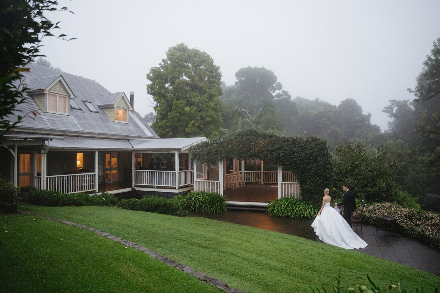 Bride on the misty lawn beside the homestead