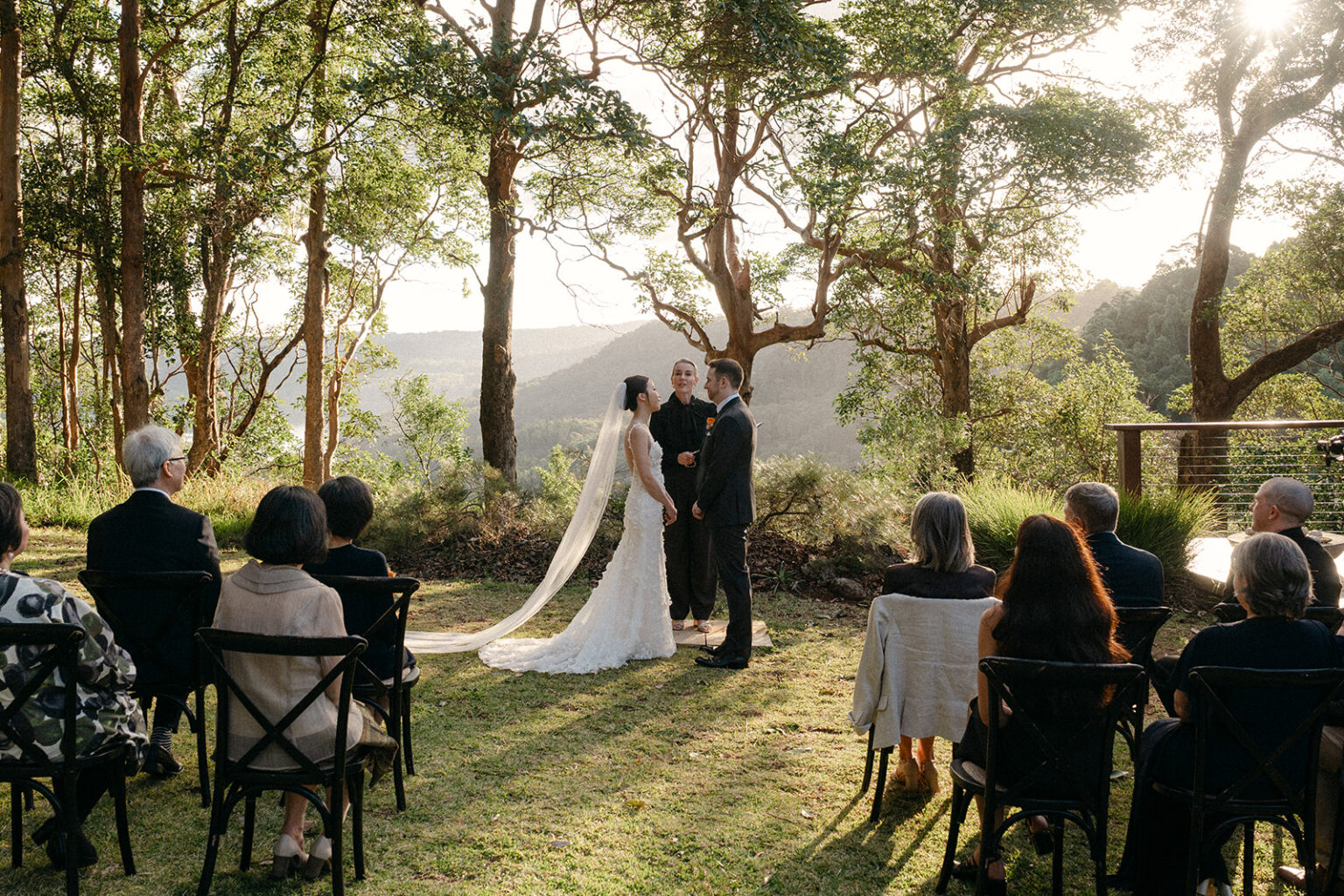 Intimate ceremony beneath the trees with guests seated