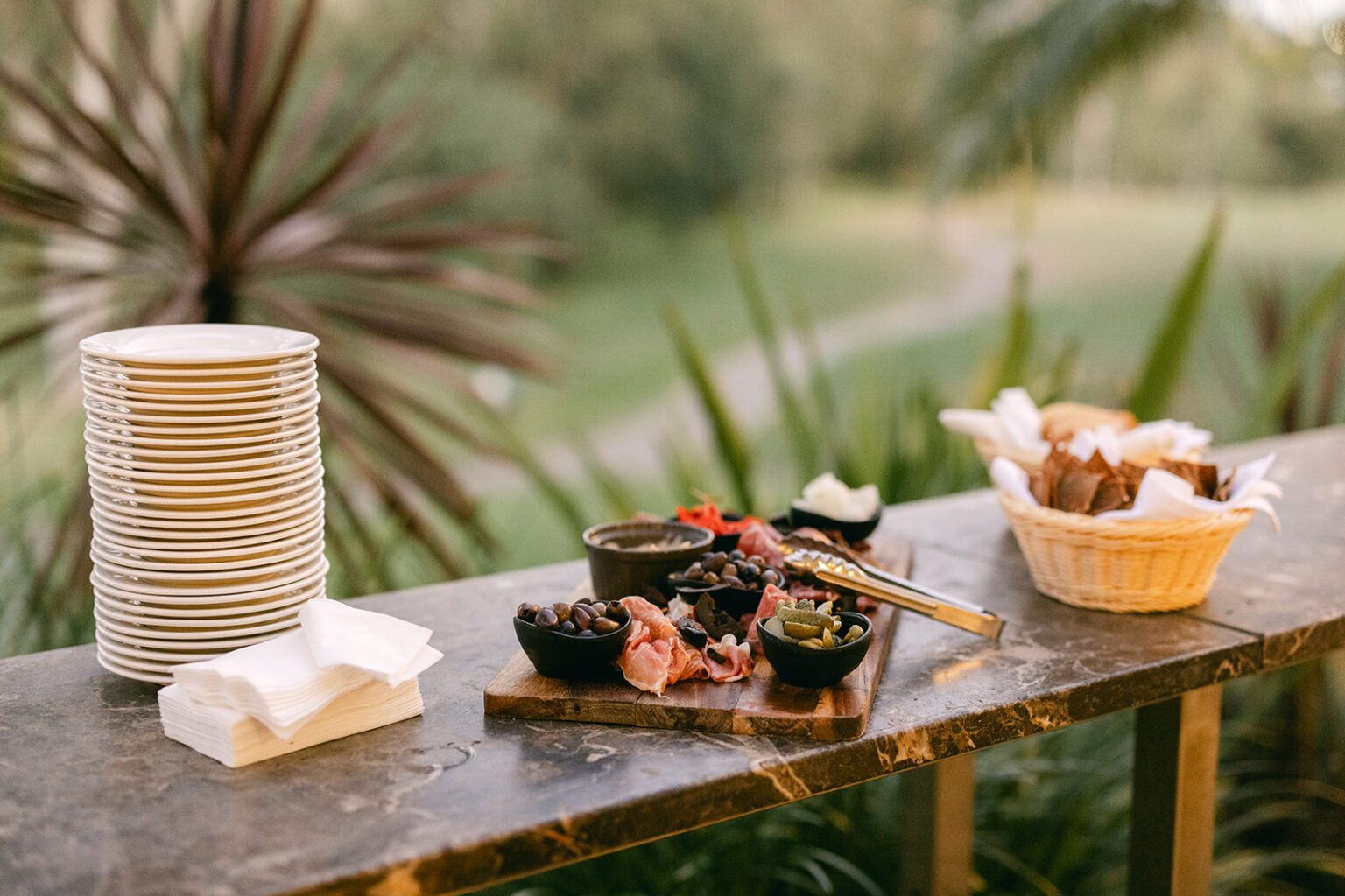 Grazing platter and plates set on an outdoor bar