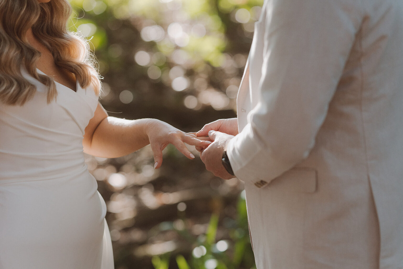 Close-up of the groom placing the ring on the bride's finger