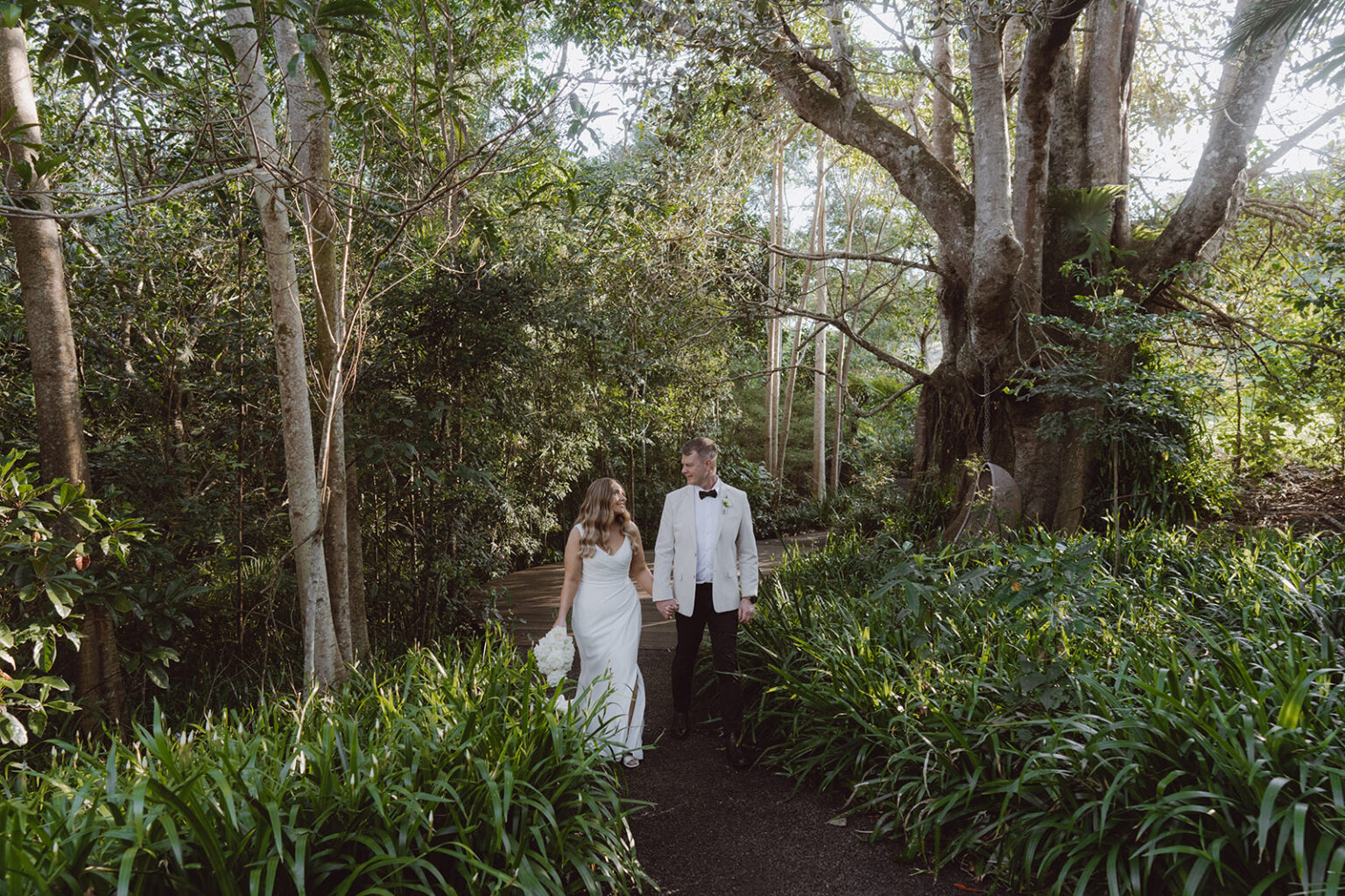 Couple walking along a rainforest path lined with gardens
