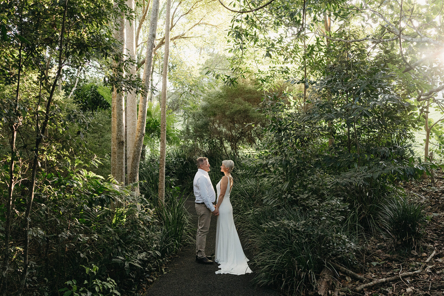 Couple on a rainforest path among tall trees