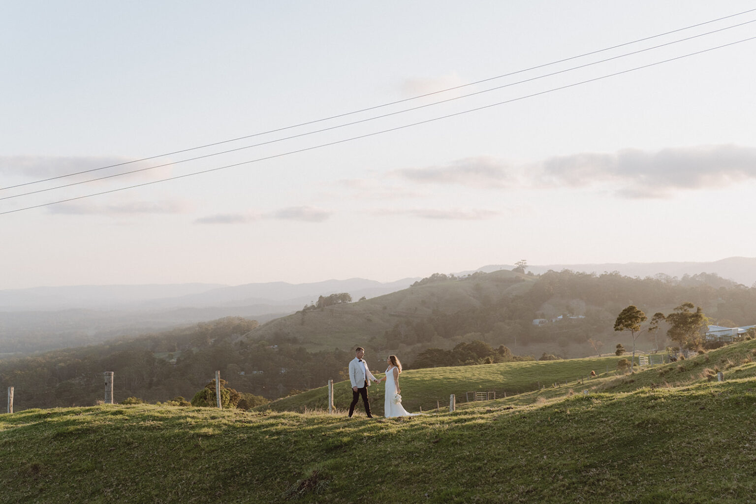 Couple on a hilltop at sunset overlooking the valley