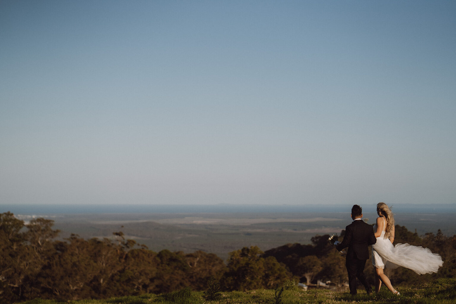 Couple on a hilltop overlooking the coast at dusk