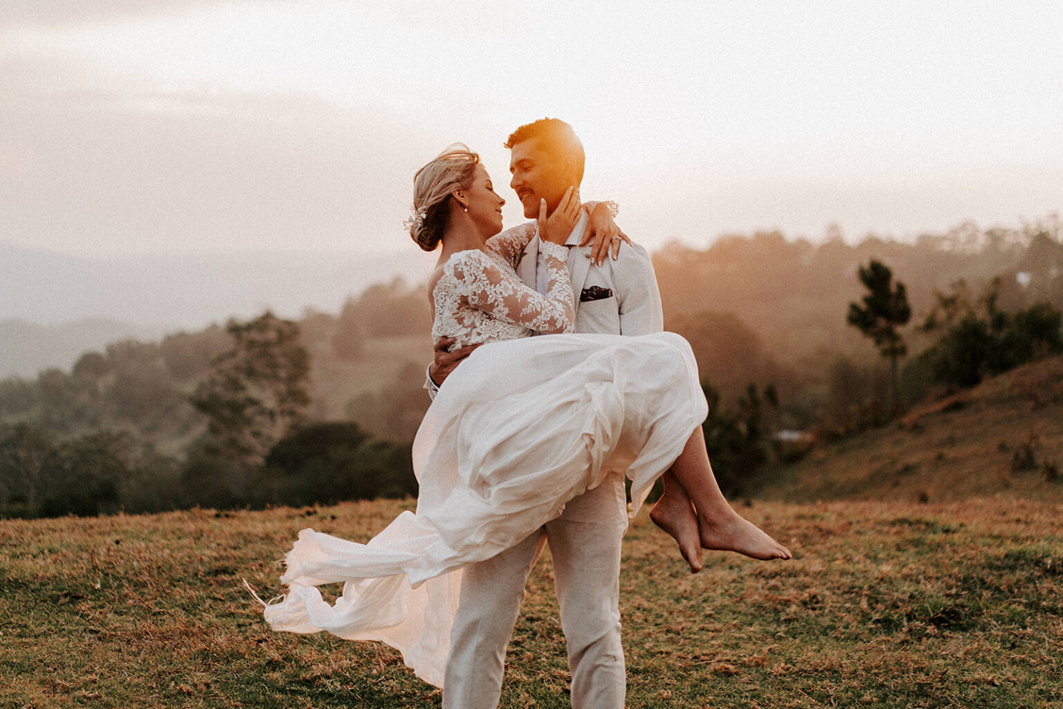 Groom carrying the bride on a hilltop at sunset, Sunshine Coast Hinterland