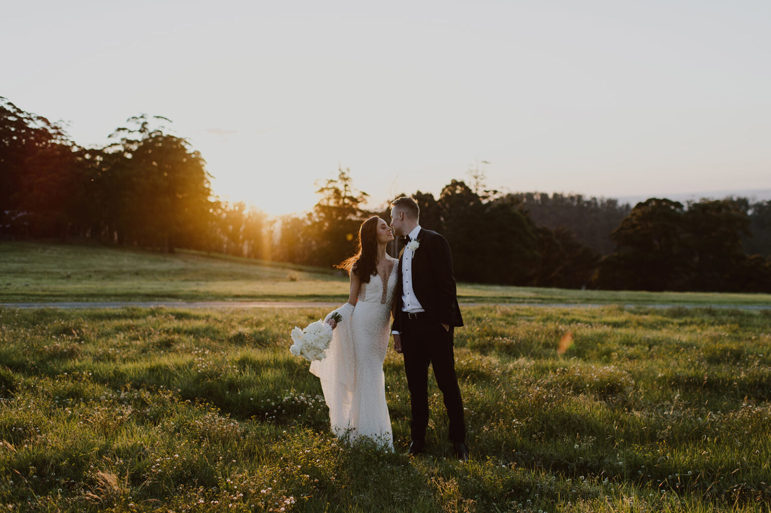 Couple standing in the meadow at sunset