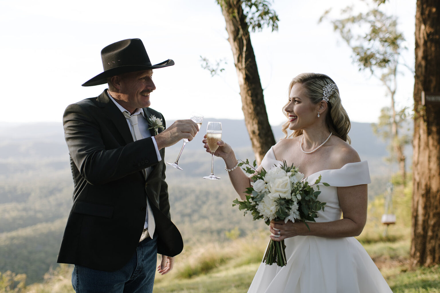 Bride and groom toasting with champagne at the lookout