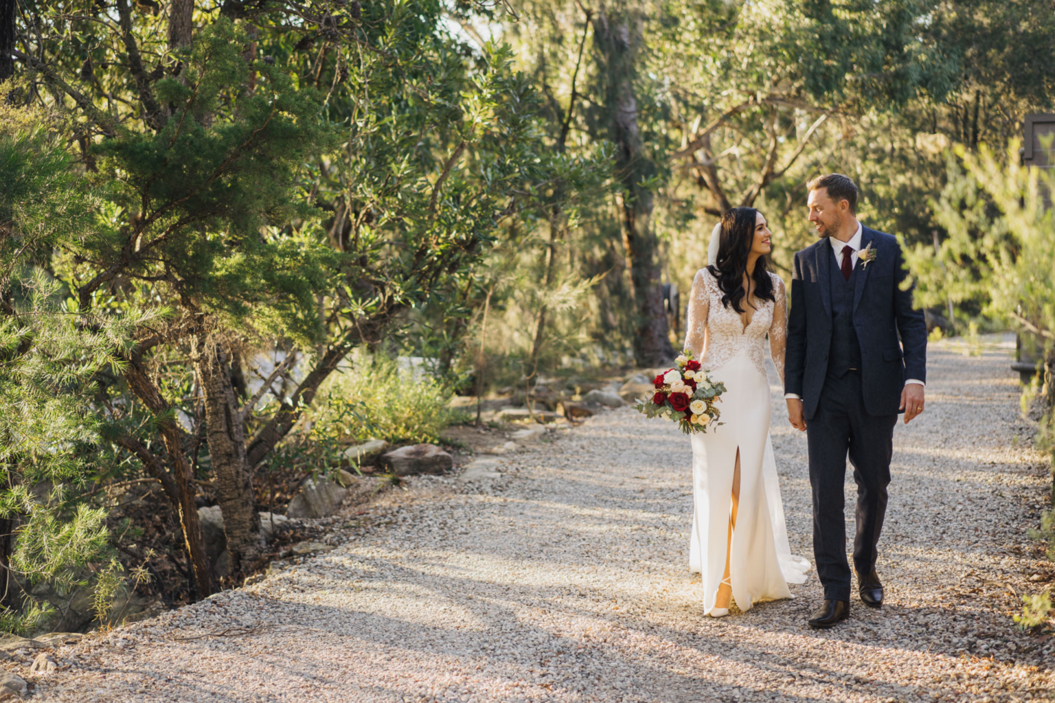 Bride and groom walking along a bush track at golden hour