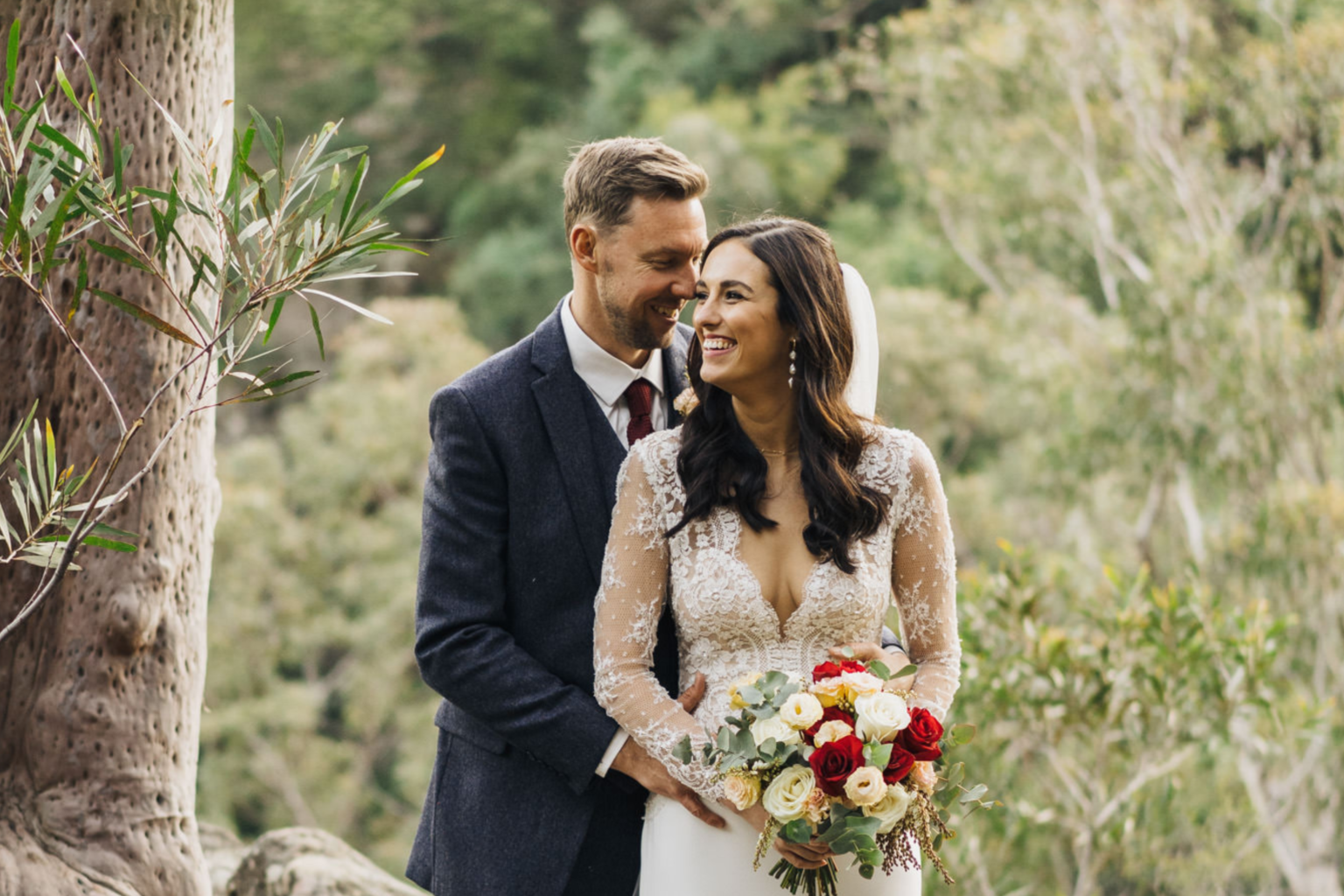 Bride and groom smiling beneath the gum trees at Spicers Sangoma Retreat