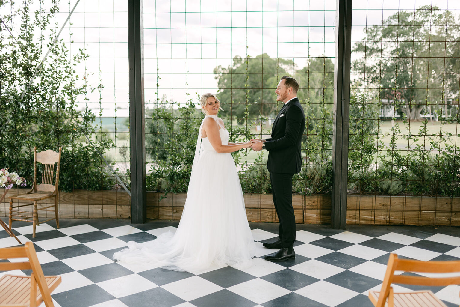 Couple holding hands during their ceremony in the Conservatory