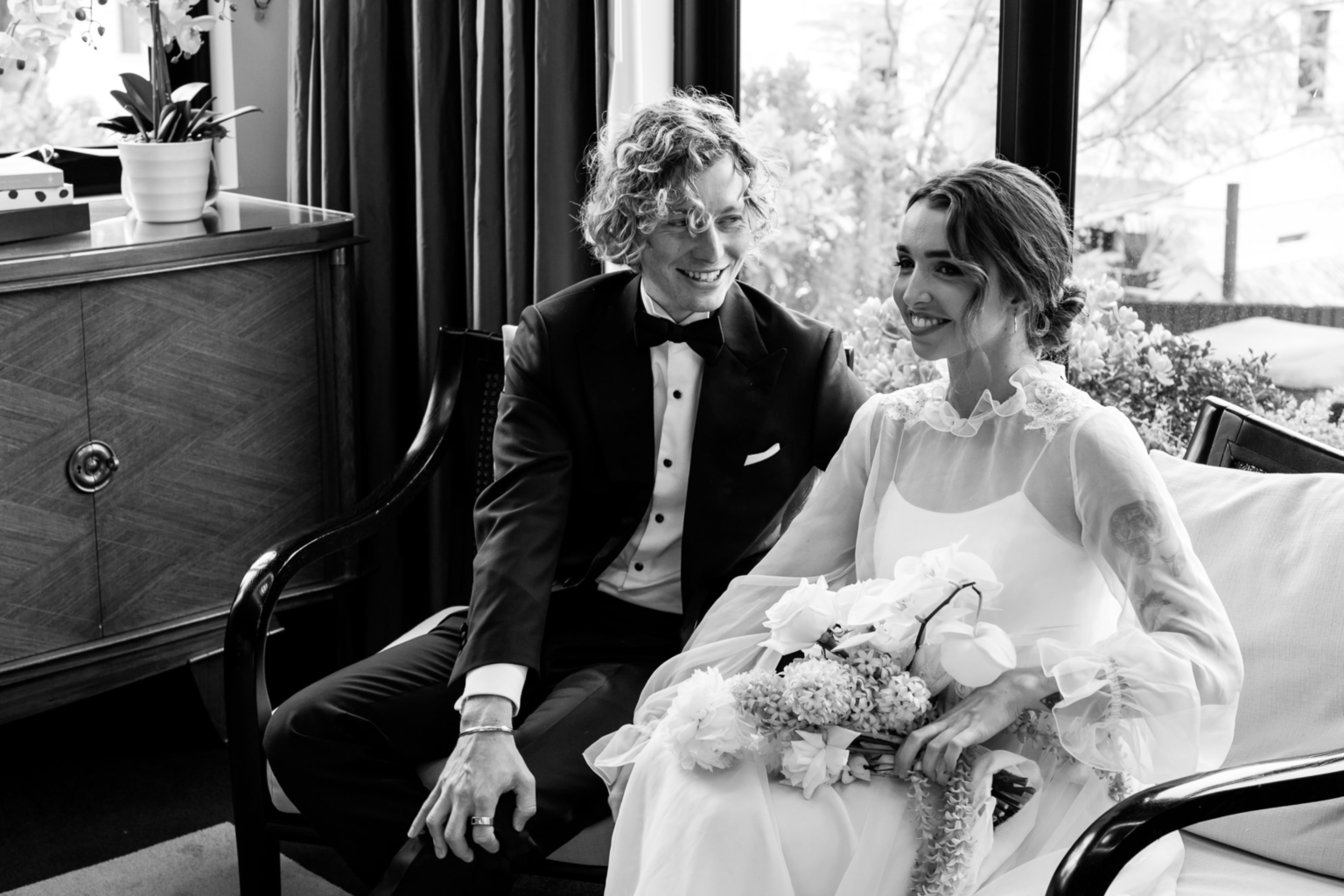 Black-and-white photo of the couple seated together in the lounge