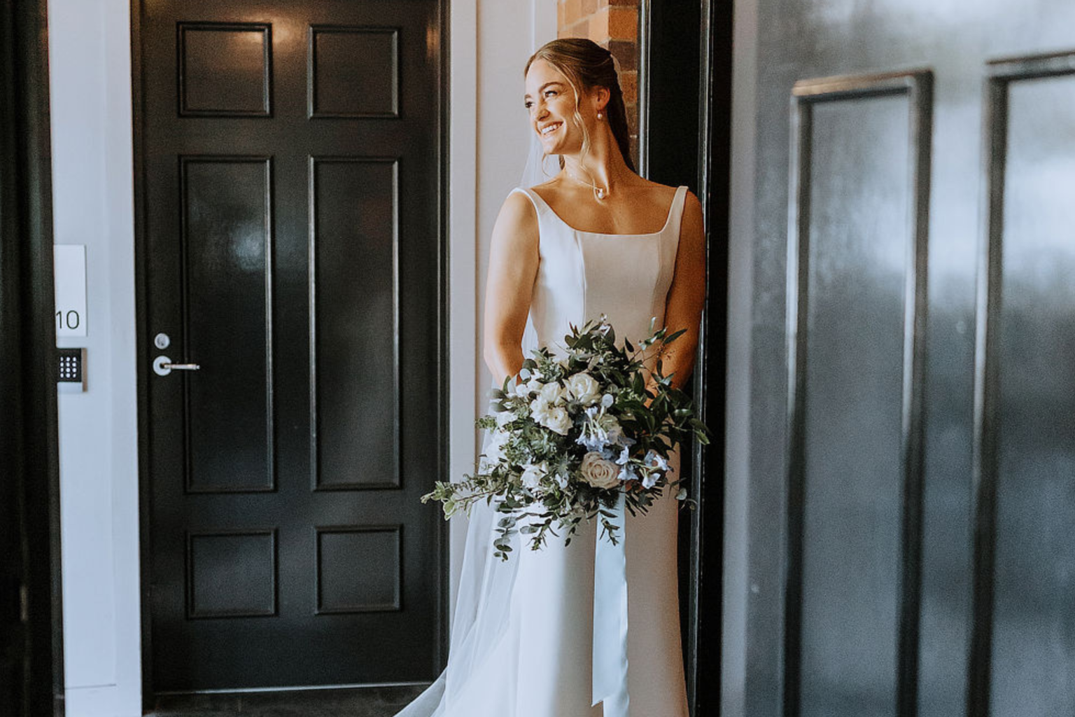 Bride holding her bouquet in a doorway at Spicers Balfour Hotel