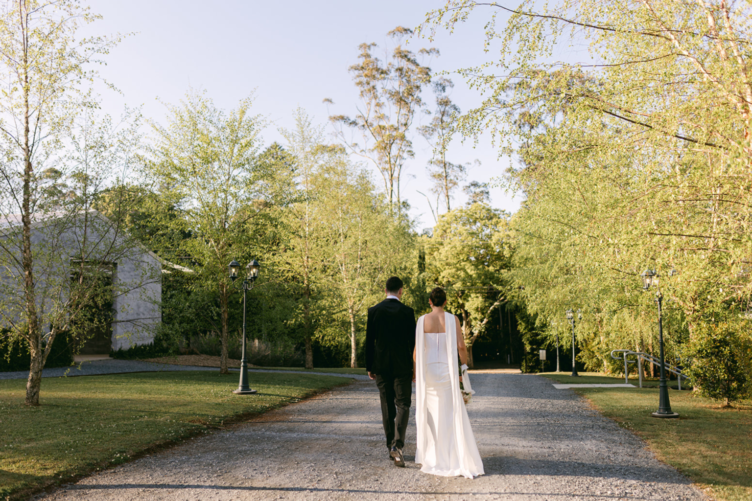 Couple walking down the tree-lined drive at Wynmère Estate