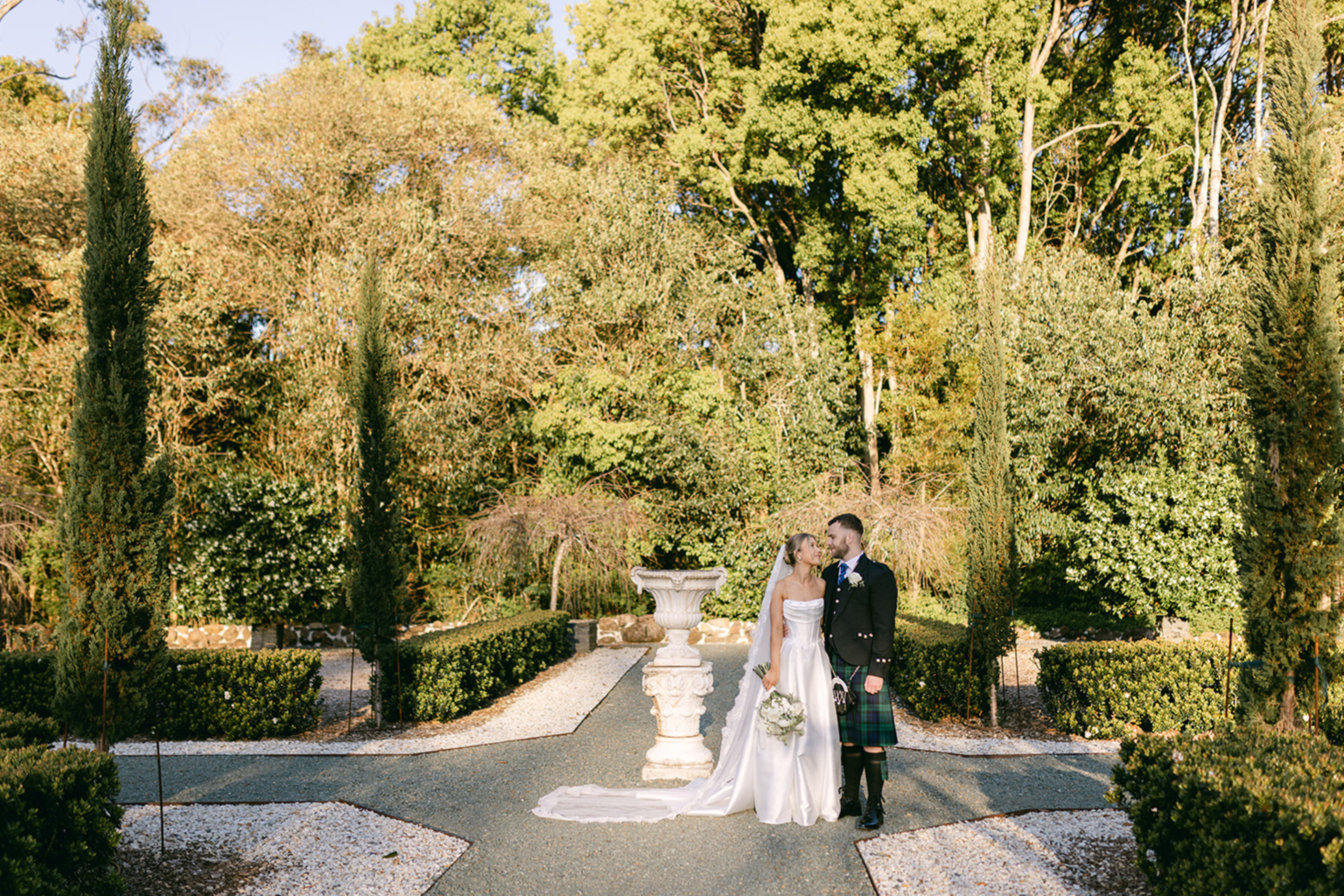 Couple standing by the garden fountain at Wynmère Estate