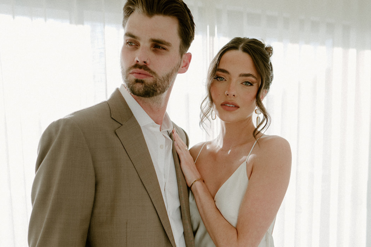 Couple posing together in a light-filled suite at Bannisters