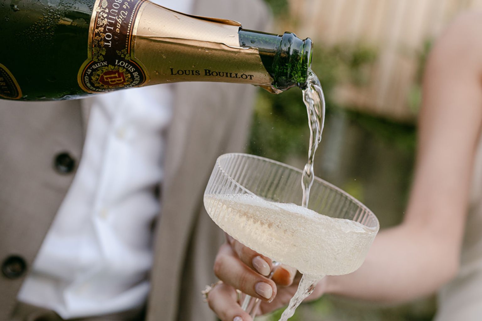 Champagne being poured into a coupe glass