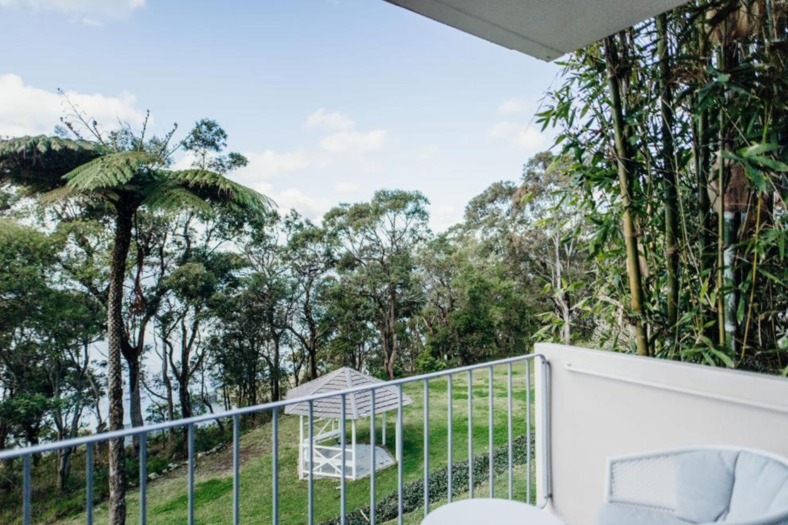 Ocean-view balcony overlooking tree ferns at Bannisters
