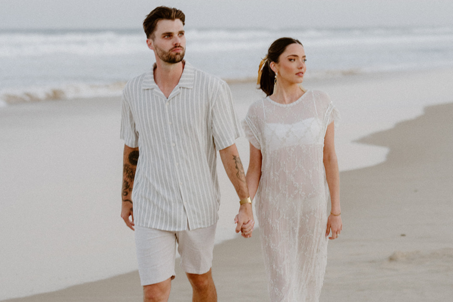 Couple walking hand in hand on the beach at Port Stephens