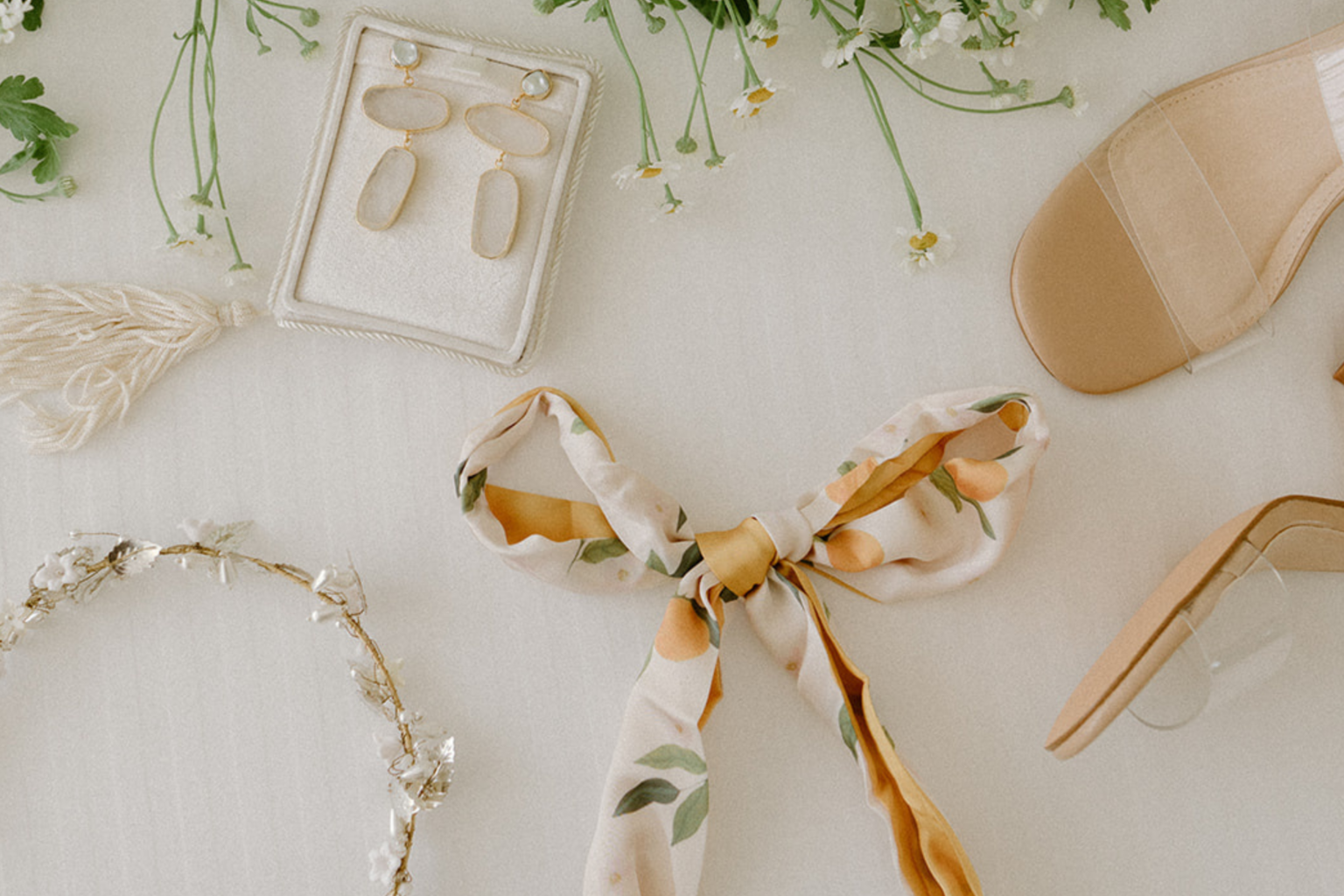 Bridal accessories flat lay with earrings, hair ribbon and heels