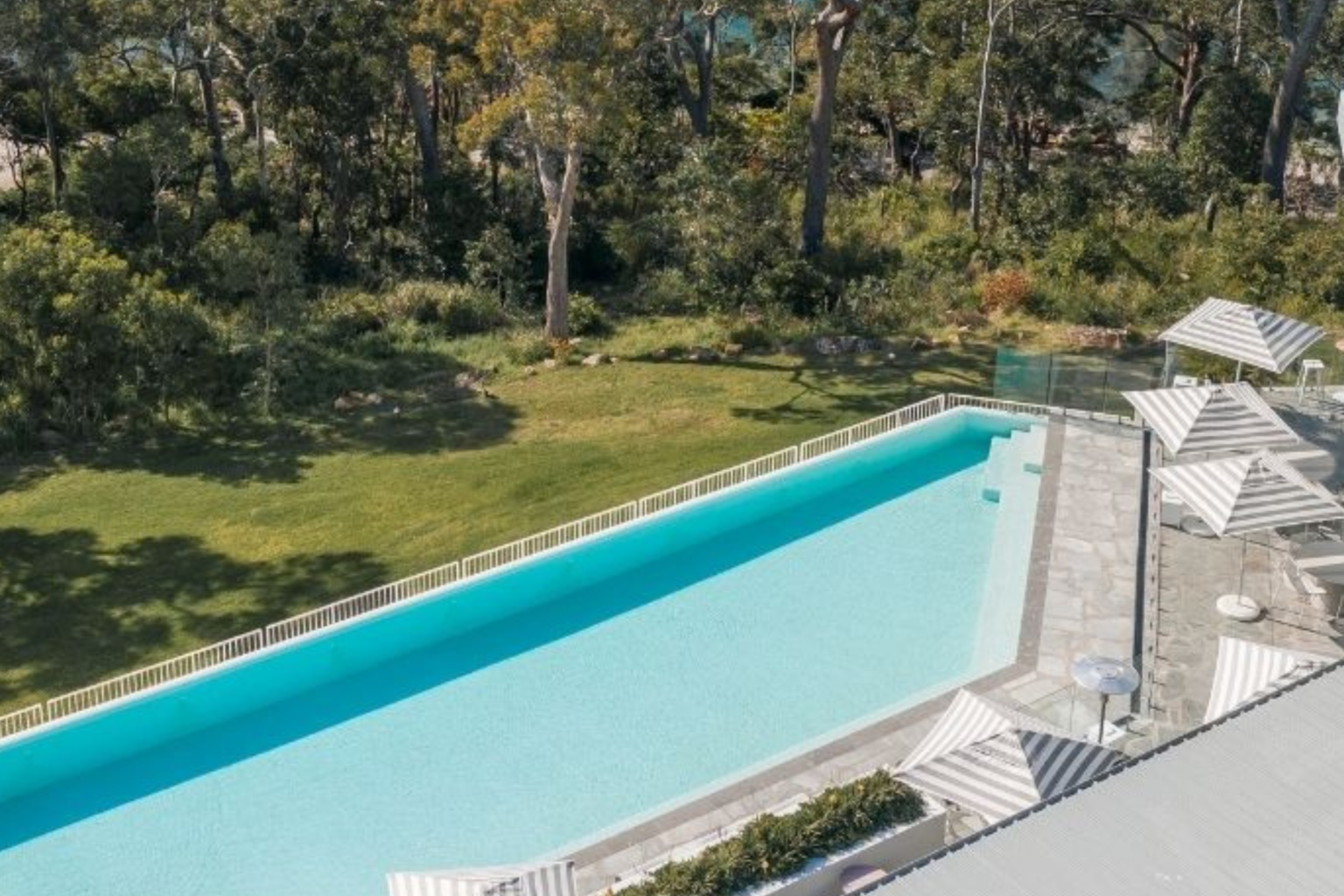 Long infinity pool bordered by bushland at Bannisters Port Stephens